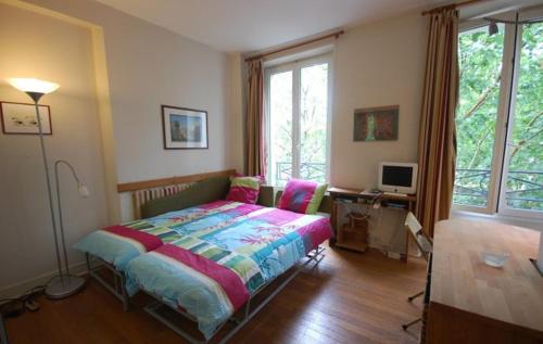 a bedroom with a bed and a desk and window at Studio near UNESCO - Invalides in Paris