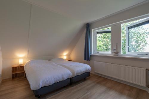 um quarto com uma cama e uma janela em Villa Duynopgangh 16 Julianadorp aan Zee em Julianadorp