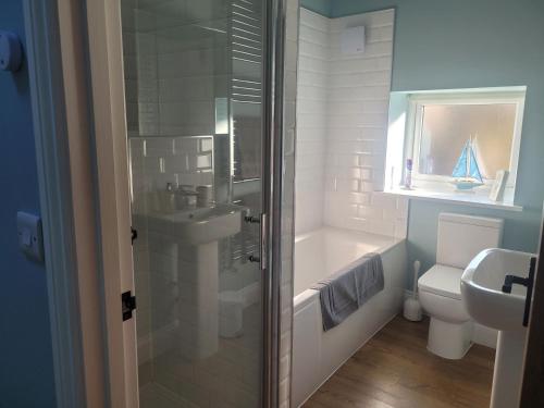 een badkamer met een douche, een wastafel en een toilet bij The Bakery in Llanddeiniol