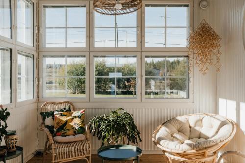a living room with two chairs and windows at Boutique Hotel Villa Klubiranta in Halli