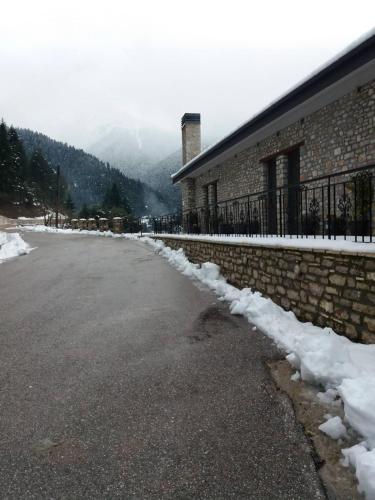 a snow covered street next to a building at Δωμάτια με θέα in Méga Khoríon