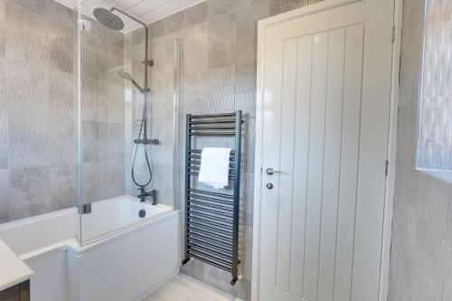 a bathroom with a white tub and a shower at #Upmarket, Exceptional 4 bed house, with free parking, close to KFc McDonald ALDI Dominos and centre in Sheffield