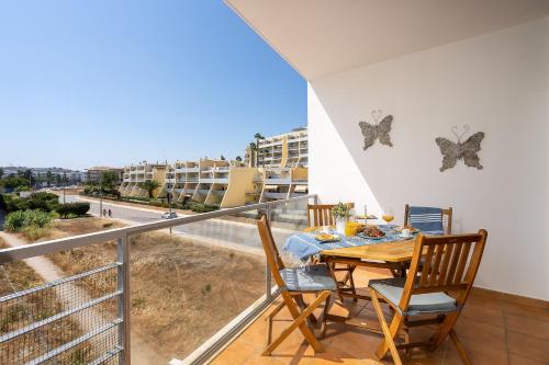 uma varanda com uma mesa com borboletas na parede em Sea La Vie Beach & Golf Apartment em Lagos