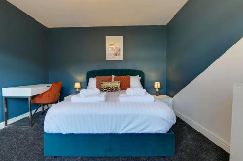 #Upmarket, Exceptional 4 bed house, with free parking, close to KFc McDonald ALDI Dominos and centre في شيفيلد: غرفة نوم زرقاء مع سرير ومكتب