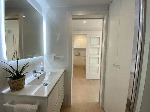 Baño blanco con lavabo y espejo en Montaber Apartments - Sant Pol de Mar en San Pol de Mar