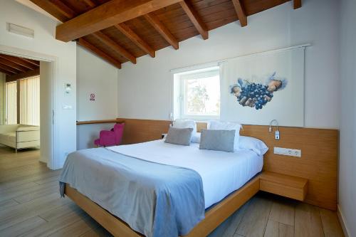 a bedroom with a large bed with white sheets and a window at Hotel Nande in Nieves