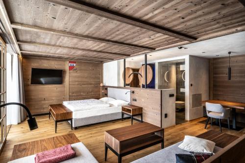 a bedroom with a bed and a wooden ceiling at Ansitz Velseck-Residence Hotel in Tires