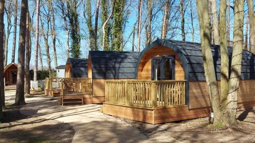 a small cabin in the woods with a fence at Pinewood - At Port Lympne Reserve in Hythe