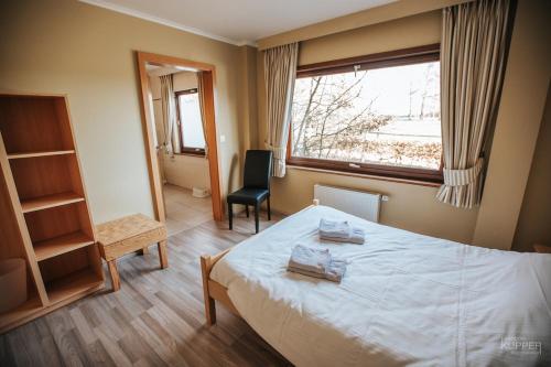 um quarto com uma cama, uma janela e uma cadeira em L'Aurore des Hautes Fagnes 30 pers- Malmedy, vue exceptionnelle, wellness em Malmedy