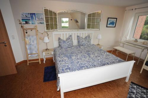 a bedroom with a bed with a blue and white comforter at Ferienwohnung Zum Königsmoor 65336 in Moormerland