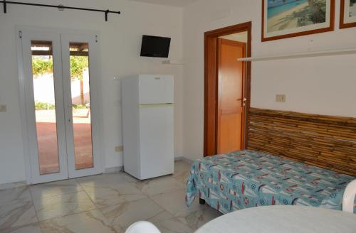 a living room with a refrigerator and a table at Onda Su Onda Appartamenti in Seccheto