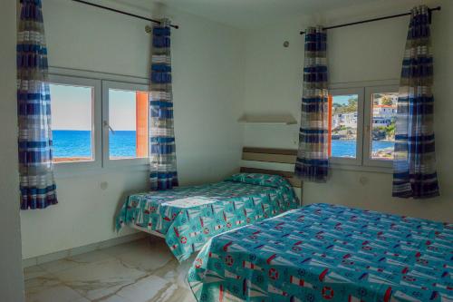 a bedroom with two beds and a view of the ocean at Onda Su Onda Appartamenti in Seccheto