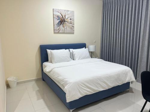a bed with a blue headboard in a bedroom at 3 Bed rooms Villa at Mina Alfajer Resort Dibba - Al-Fujairah in Rūl Ḑadnā