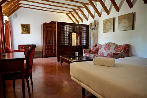 1 dormitorio con 1 cama, mesa y sillas en DWO Convento la Magdalena, en Antequera