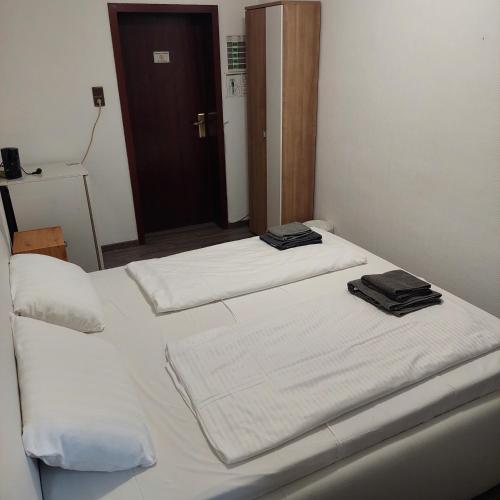 two beds in a room with white sheets and towels at Hotel Berliner Hof in Düsseldorf