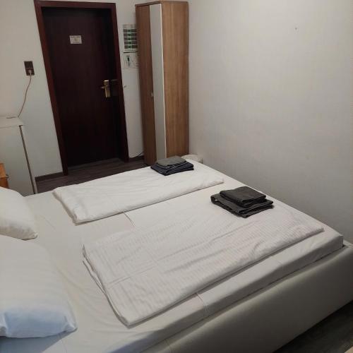 two beds in a room with white sheets and towels at Hotel Berliner Hof in Düsseldorf
