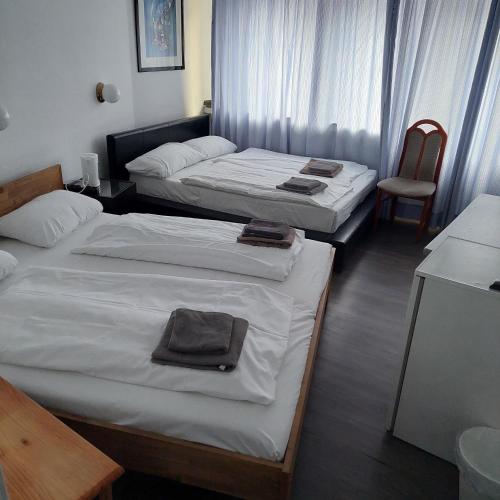 a hotel room with two beds and a chair at Hotel Berliner Hof in Düsseldorf