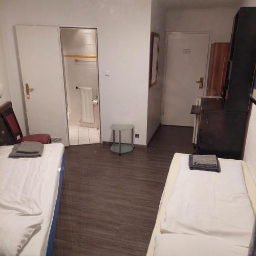 a room with two beds and a hallway with a door at Hotel Berliner Hof in Düsseldorf