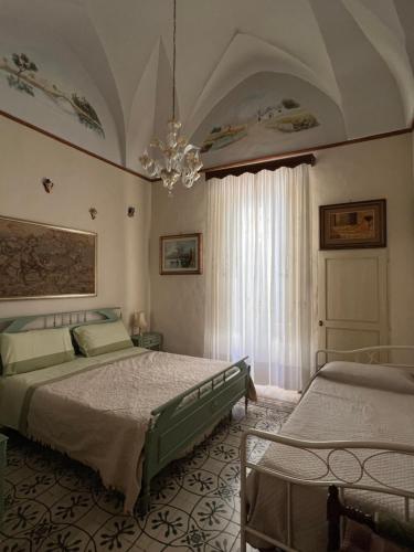 a bedroom with two beds and a chandelier at M&M Palazzotto Maria in Fasano