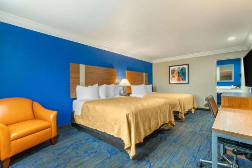 ein Hotelzimmer mit 2 Betten und einem Stuhl in der Unterkunft Quality Inn & Suites Vacaville in Vacaville