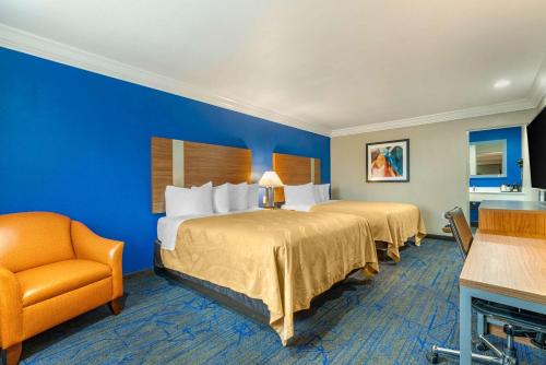 una habitación de hotel con 2 camas y una silla en Quality Inn & Suites Vacaville en Vacaville