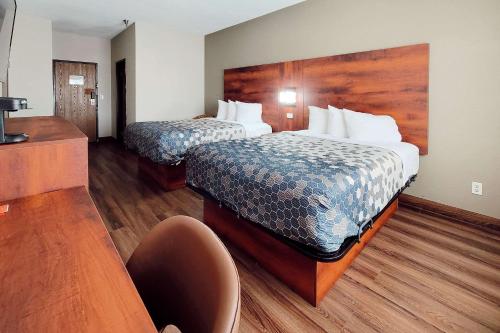 een hotelkamer met 2 bedden en een stoel bij Econo Lodge in Fargo