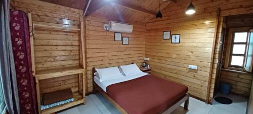 a bedroom with a bed in a wooden room at The Jungle Resort Amba in Chandoli