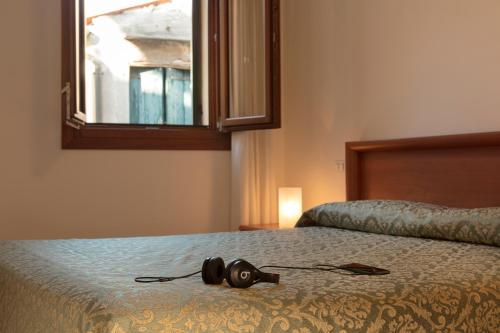 a camera sitting on a bed in a bedroom at Hotel Commercio & Pellegrino in Venice