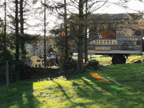 a truck parked in a yard next to a tree at 2 x Double Bed Glamping Wagon in Dalby Forest in Scarborough