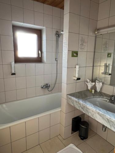 a bathroom with a tub and a sink and a bath tub at Stammhaus im Hotel Alpine Palace in Saalbach Hinterglemm