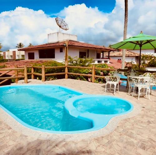 a large blue pool in the middle of a yard at Princesinha do Sul in Ilhéus