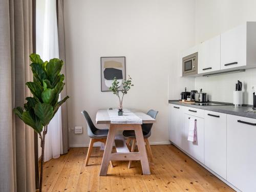 een kleine keuken met een houten tafel en stoelen bij Schoenhouse City Street in Berlijn