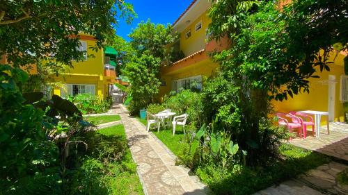un jardín con mesas y sillas frente a un edificio en Casas Amarelas, en Florianópolis