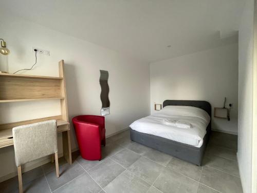 Schlafzimmer mit einem Bett, einem Schreibtisch und einem roten Stuhl in der Unterkunft Héolia - Maison à 250m de la plage Damgan in Damgan