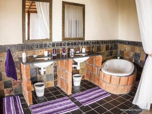 a bathroom with two sinks and a bath tub at Nghunghwa Lodge in Vila Praia Do Bilene