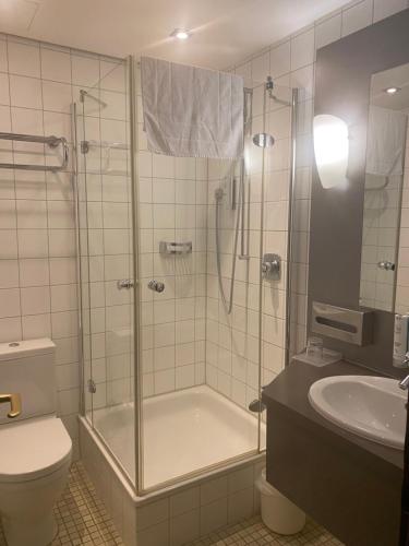 a bathroom with a shower and a toilet and a sink at Hotel Villa Sophia in Warendorf