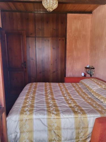a bedroom with a bed with a wooden wall at Stella D'Abruzzo in Roccaraso