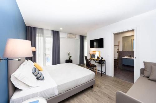 ein Hotelzimmer mit Bett und Schreibtisch in der Unterkunft Hotel Aurora in Lignano Sabbiadoro