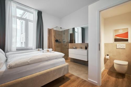a bedroom with a large bed and a bathroom at Park Avenue Apartments - Dom mit Stil - Küche - Parkplatz - WLAN - 65 Zoll TV - NETFLIX in Cologne