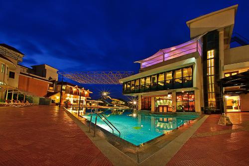 a building with a swimming pool at night at Clarks Exotica Convention Resort & Spa in Devanhalli