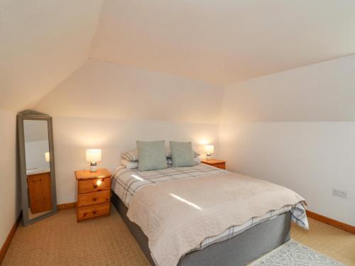a bedroom with a large bed and a mirror at The Coach House in Oban