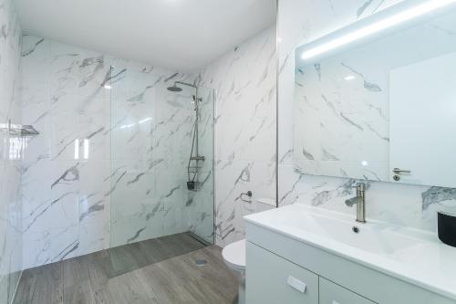 baño blanco con ducha y lavamanos en Algarve Golden Properties: Iberlagos 226, en Lagos
