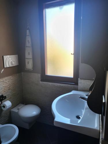 a bathroom with a sink and a toilet and a window at Stella D'Abruzzo in Roccaraso