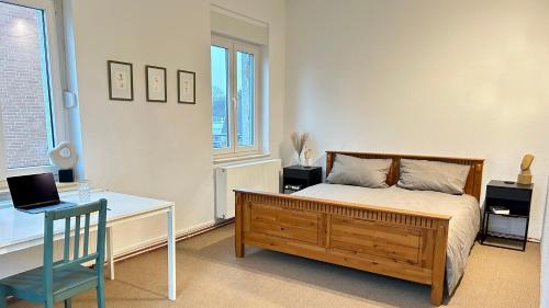 a bedroom with a bed and a desk with a laptop at Gemütliches Apartment in Gelsenkirchen