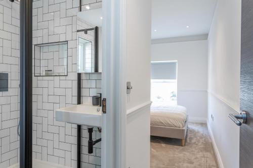 een badkamer met een wastafel en een spiegel bij The Stanley Maisonette in Teddington
