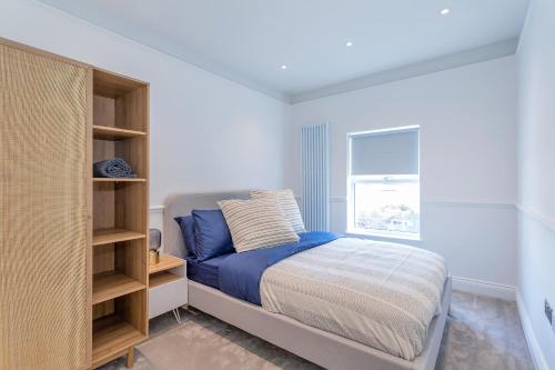 a small bedroom with a bed and a window at The Stanley Maisonette in Teddington