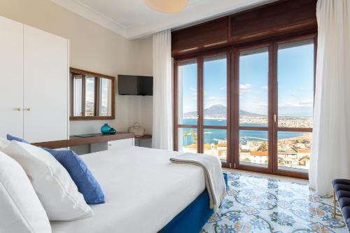 um quarto com uma cama e uma grande janela em Experience Boutique Hotel - Villa Cimmino em Castellammare di Stabia