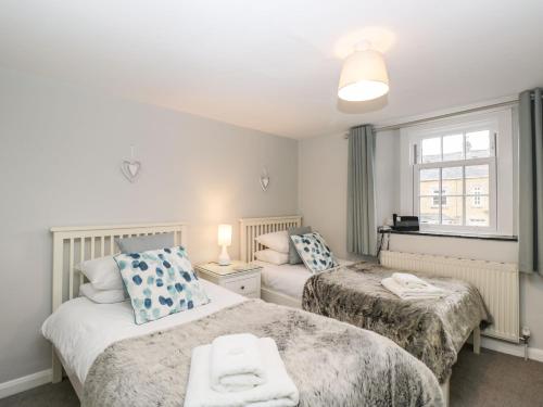 a bedroom with two beds and a window at Barton Cottage in Cheltenham
