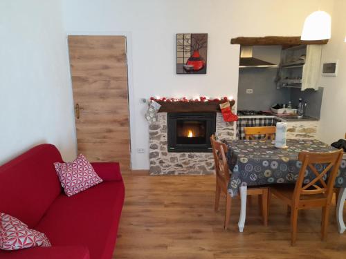 a living room with a table and a fireplace at Casa Vacanze La Mezzaluna in Molini di Triora