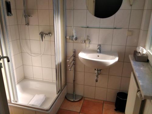 ein Bad mit einer Dusche und einem Waschbecken in der Unterkunft Gästehaus Helbighof in Neustadt an der Weinstraße